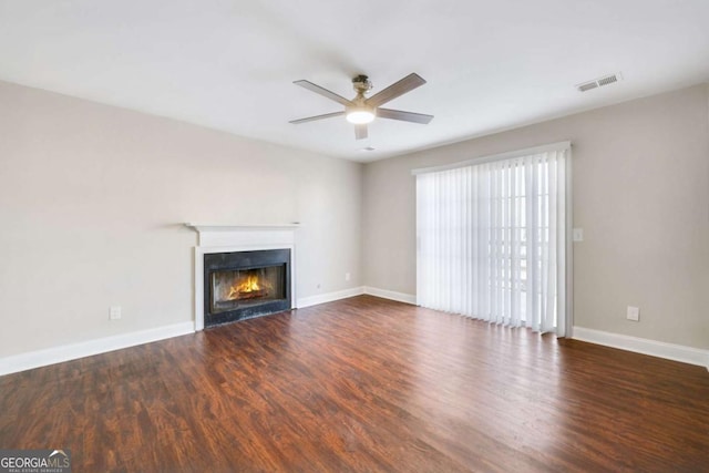 unfurnished living room with ceiling fan and dark hardwood / wood-style flooring