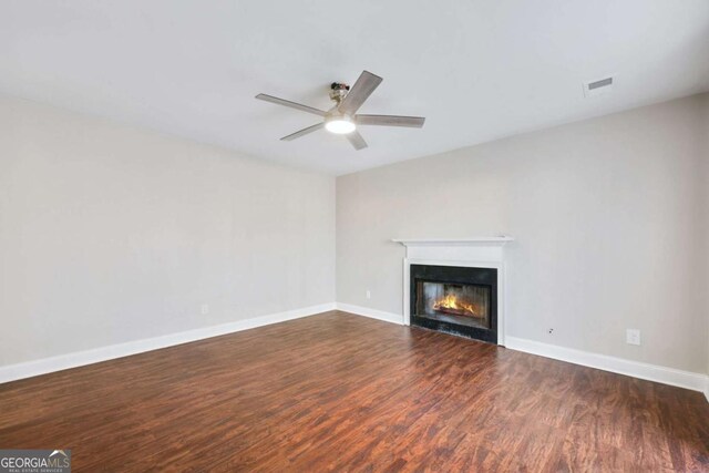 unfurnished living room with dark hardwood / wood-style floors and ceiling fan