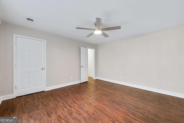 spare room with ceiling fan and dark wood-type flooring