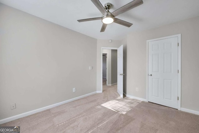 unfurnished bedroom with light colored carpet and ceiling fan