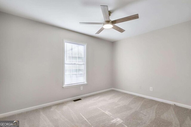 carpeted spare room featuring ceiling fan