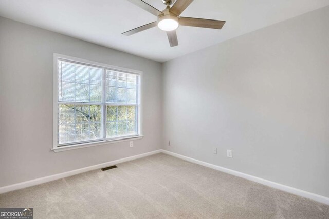 unfurnished room featuring light carpet and ceiling fan