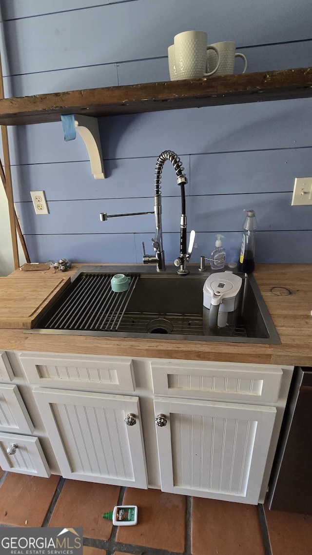 details with butcher block counters, sink, and wooden walls