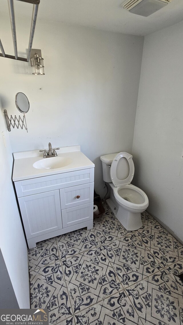 bathroom with tile patterned floors, vanity, and toilet