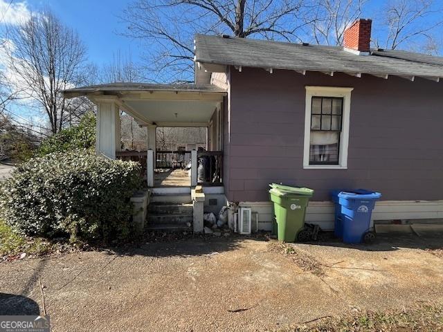 view of side of property featuring covered porch