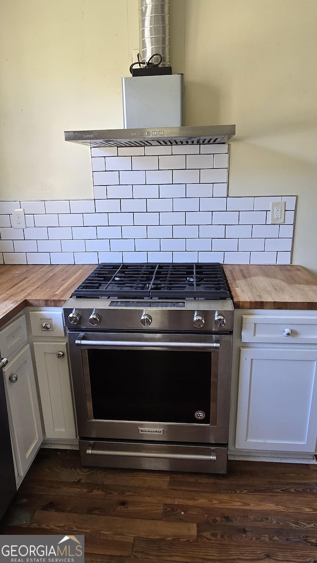 kitchen with dark wood-type flooring, wooden counters, stainless steel gas stove, white cabinetry, and decorative backsplash