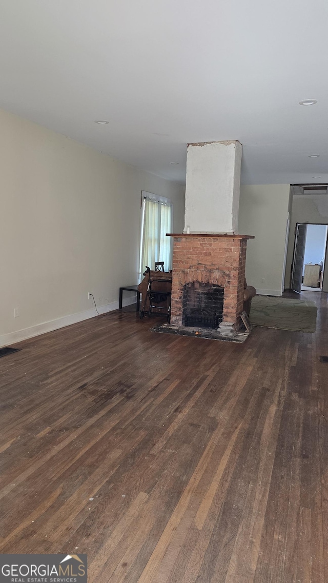 living room with dark hardwood / wood-style floors and a fireplace