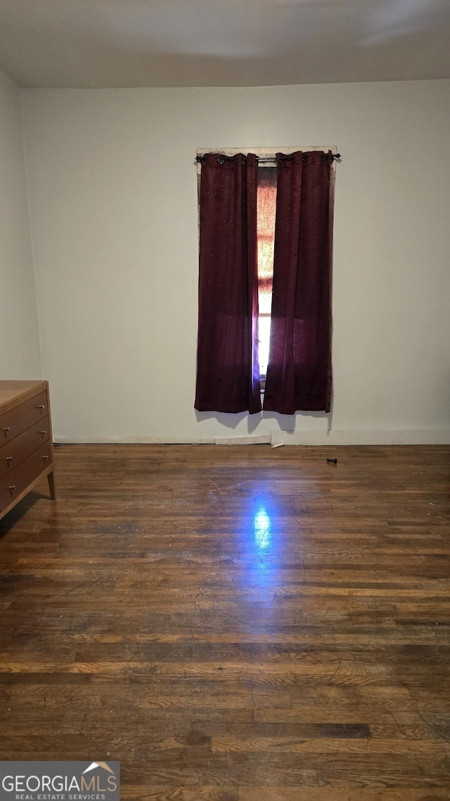 spare room with dark wood-type flooring