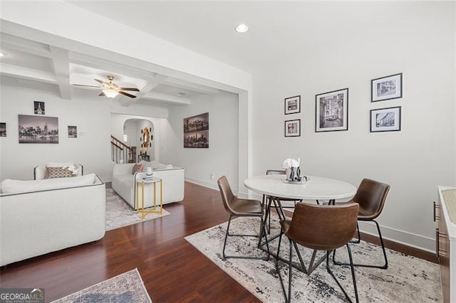 dining room with beamed ceiling, dark wood-type flooring, ceiling fan, and coffered ceiling