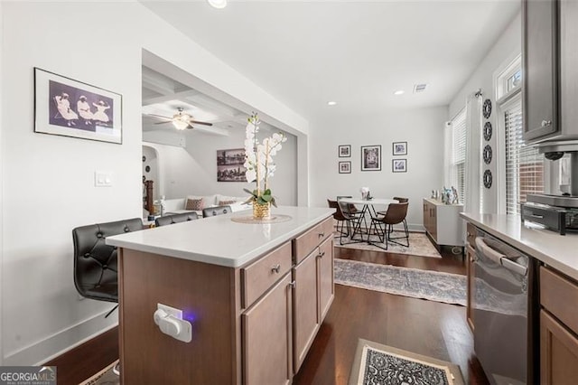 kitchen with ceiling fan, dishwasher, a center island, coffered ceiling, and dark hardwood / wood-style flooring