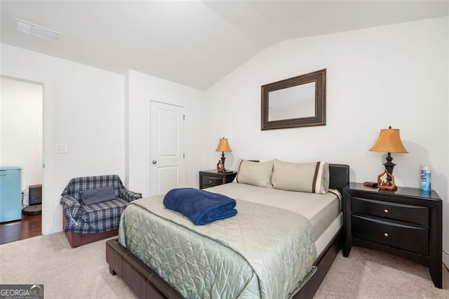 bedroom featuring light colored carpet and vaulted ceiling