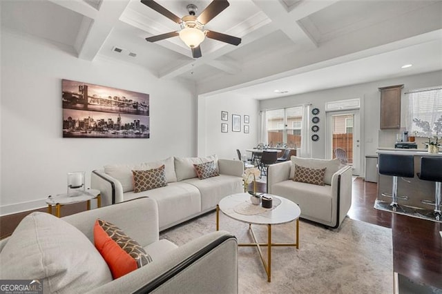 living room with beam ceiling, light wood-type flooring, ceiling fan, and coffered ceiling