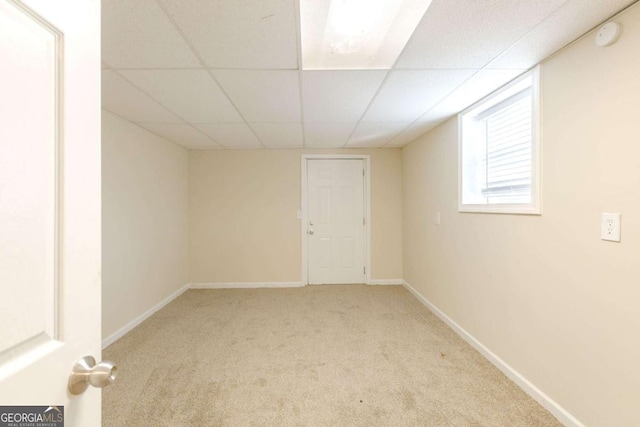 basement with light carpet and a drop ceiling