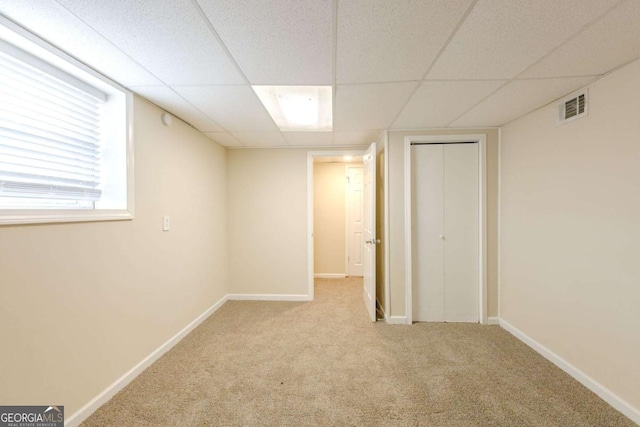 basement with carpet flooring and a paneled ceiling