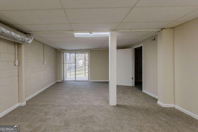 basement with a paneled ceiling and light carpet