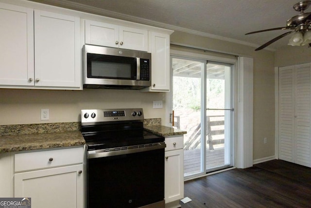 kitchen with crown molding, dark hardwood / wood-style floors, dark stone countertops, white cabinetry, and stainless steel appliances