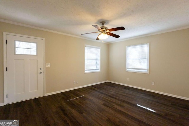 foyer featuring ornamental molding, a textured ceiling, dark wood-type flooring, and a healthy amount of sunlight