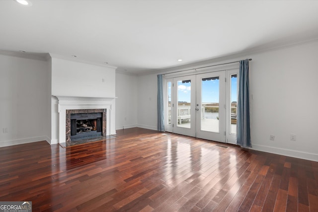 unfurnished living room featuring crown molding, french doors, and dark wood-type flooring