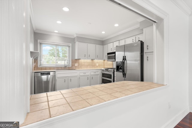 kitchen with sink, ornamental molding, tasteful backsplash, white cabinetry, and stainless steel appliances