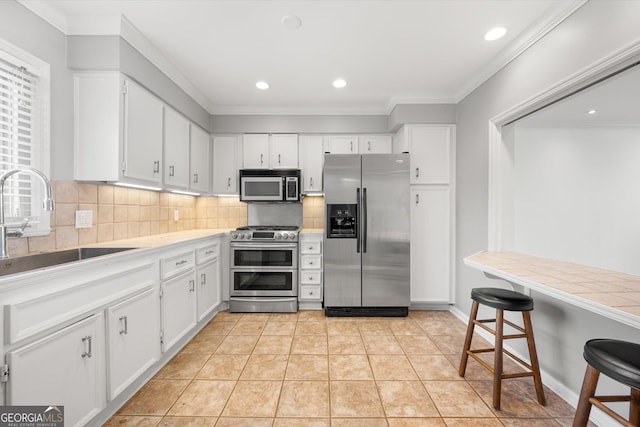 kitchen with white cabinetry, sink, light tile patterned flooring, and appliances with stainless steel finishes