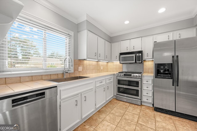 kitchen with white cabinets, light tile patterned floors, stainless steel appliances, and sink