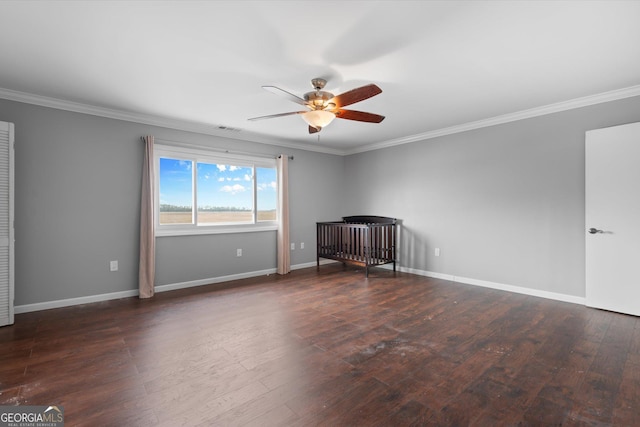 empty room featuring dark wood-type flooring, ceiling fan, and crown molding