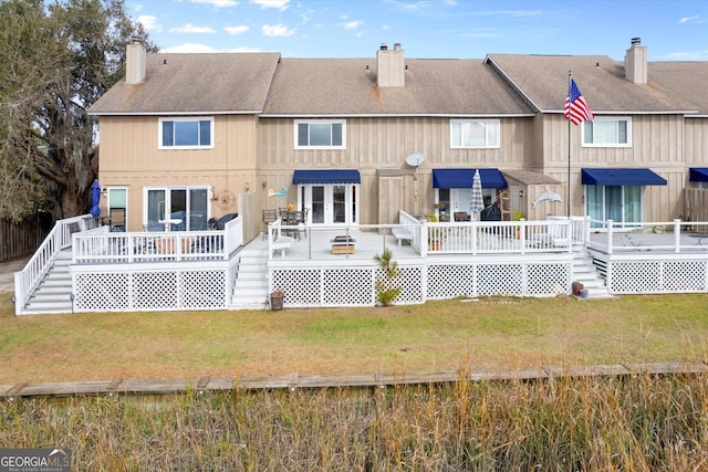 rear view of property featuring a wooden deck and a yard