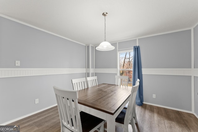 dining space with dark hardwood / wood-style flooring and ornamental molding