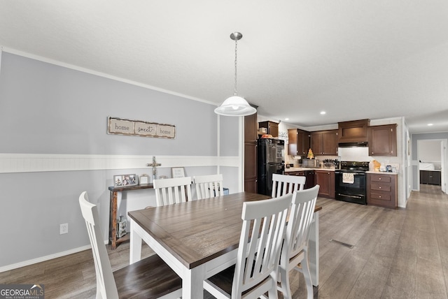 dining area with light hardwood / wood-style flooring and crown molding