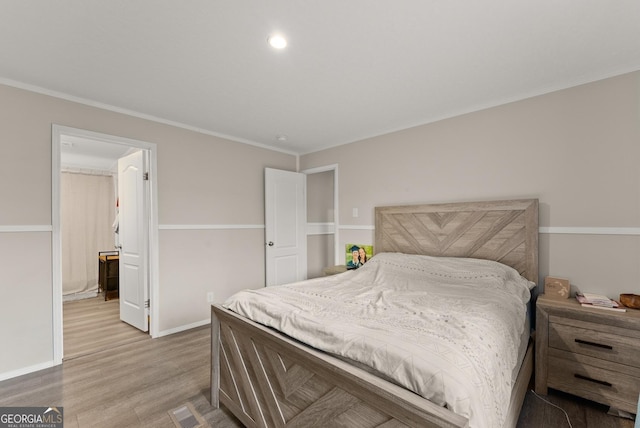 bedroom with wood-type flooring and ornamental molding