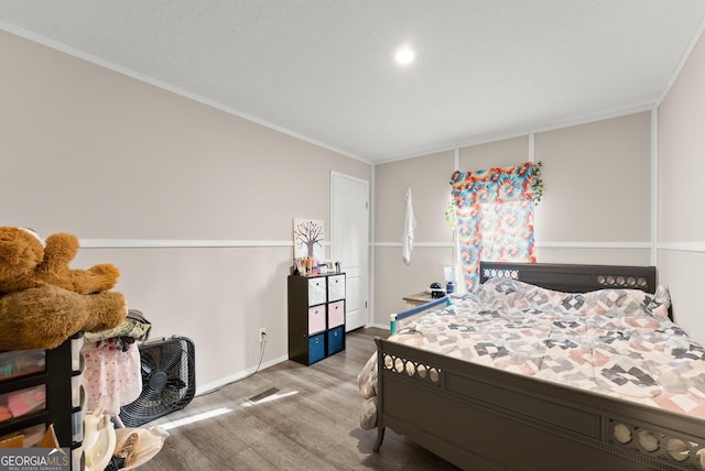 bedroom featuring hardwood / wood-style flooring and ornamental molding