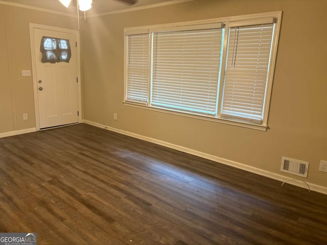 foyer with dark wood-type flooring, ceiling fan, and ornamental molding