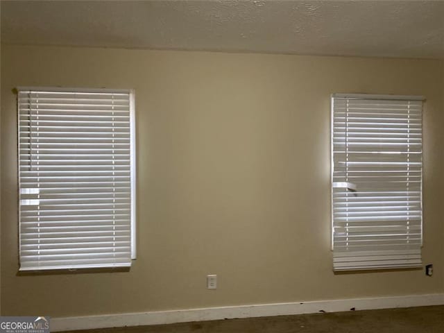 unfurnished room with a textured ceiling