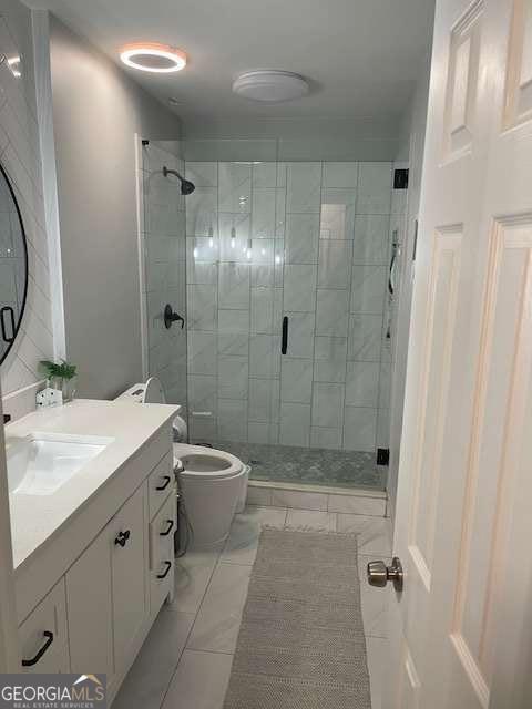 bathroom with tile patterned flooring, vanity, an enclosed shower, and toilet