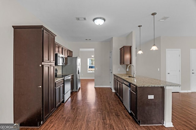 kitchen with sink, light stone countertops, decorative light fixtures, dark brown cabinetry, and stainless steel appliances