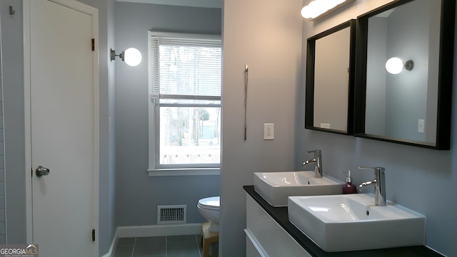 bathroom featuring toilet, tile patterned floors, and sink