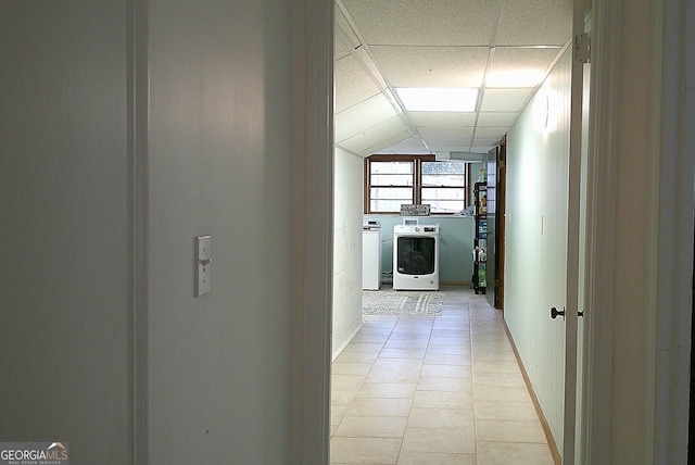 hallway featuring a paneled ceiling and washer and dryer