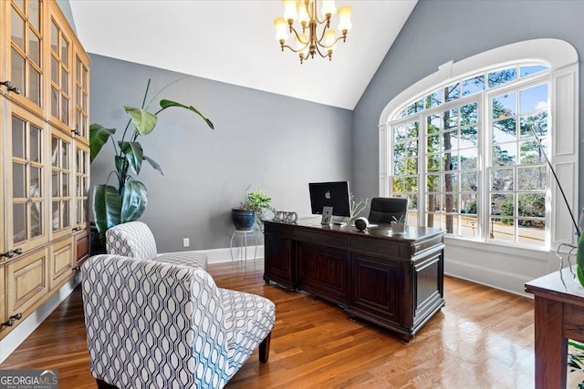 home office featuring vaulted ceiling, an inviting chandelier, and hardwood / wood-style flooring