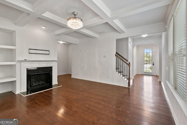 unfurnished living room featuring beamed ceiling, built in shelves, a chandelier, and coffered ceiling