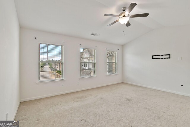carpeted empty room featuring ceiling fan and vaulted ceiling
