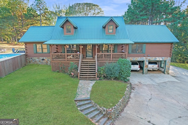 log cabin featuring a carport, covered porch, and a front lawn