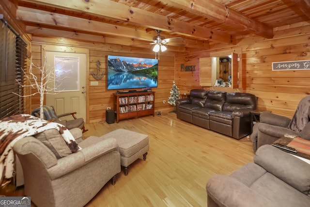 interior space featuring wood walls, ceiling fan, beamed ceiling, light hardwood / wood-style floors, and wood ceiling