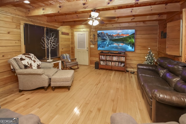 living room featuring ceiling fan, wooden ceiling, beamed ceiling, light hardwood / wood-style floors, and wood walls