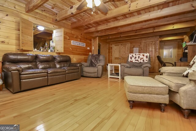 interior space featuring wood ceiling, ceiling fan, wooden walls, beam ceiling, and light hardwood / wood-style floors