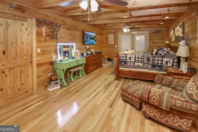 bedroom with wooden walls, beamed ceiling, light hardwood / wood-style floors, and wooden ceiling