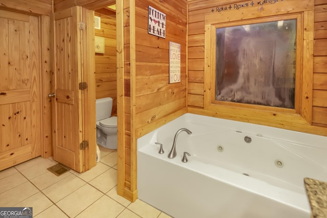 bathroom featuring tile patterned floors, a bathtub, wood walls, and toilet