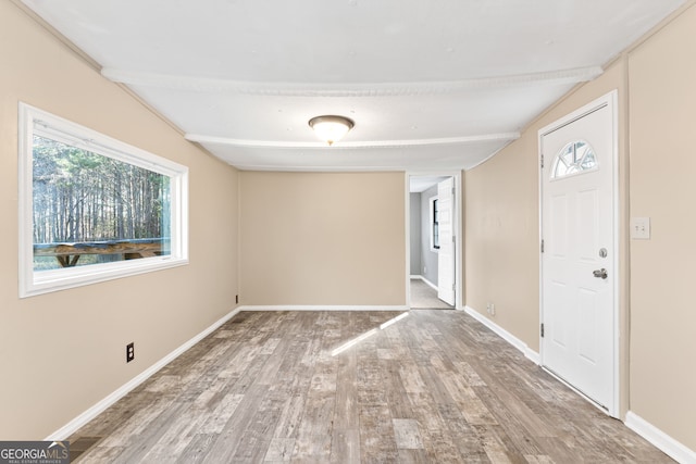 entrance foyer featuring hardwood / wood-style floors and lofted ceiling with beams