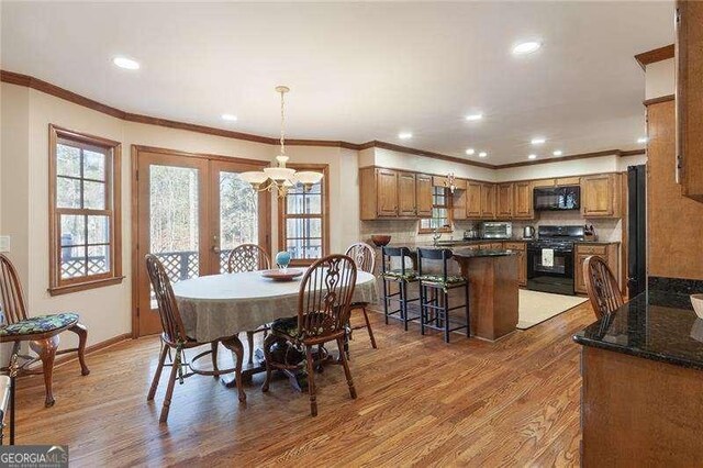 dining room with french doors, wood-type flooring, a notable chandelier, and ornamental molding