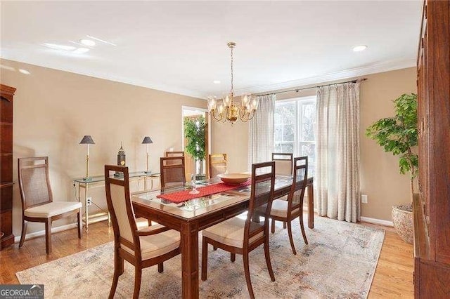 dining room featuring light hardwood / wood-style floors, crown molding, and a chandelier