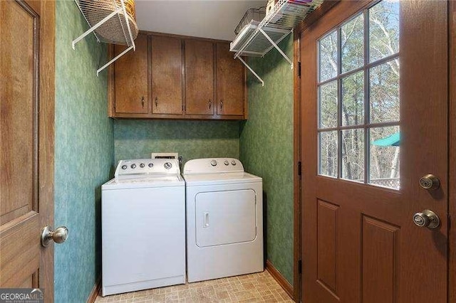 laundry area featuring separate washer and dryer and cabinets